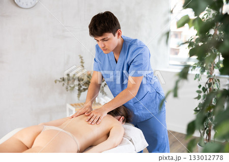 Massage by man in blue scrubs 133012778