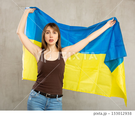 Young sad woman holding flag of Ukraine Young sad woman holding flag of Ukraine 133012938