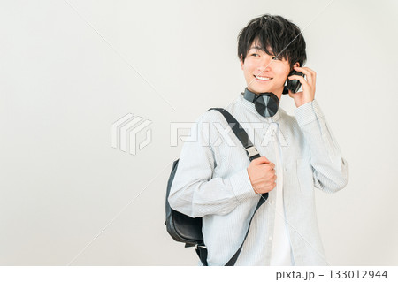 通学中にヘッドホンで音楽を聴く学生,大学生の男性(進学,受験,キャンパスライフ) 通学中にヘッドホンで音楽を聴く学生,大学生の男性(進学,受験,キャンパスライフ) 133012944