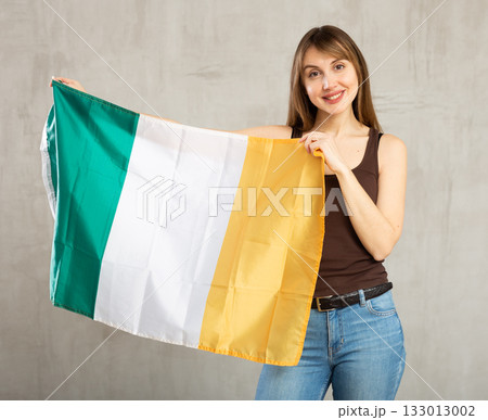 Pretty girl holding the Ireland flag in her hands 133013002