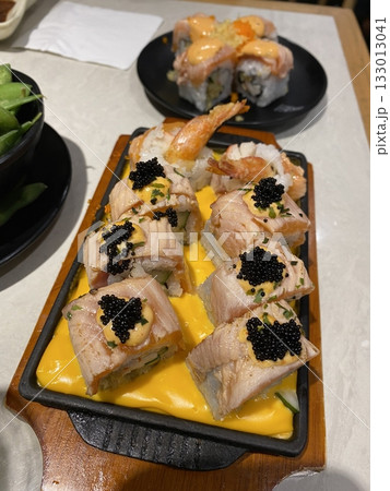 An assortment of fresh sushi, artfully arranged with a variety of toppings and vibrant colors. This traditional Japanese dish combines vinegared rice, seafood, and vegetables for an experience. 133013041