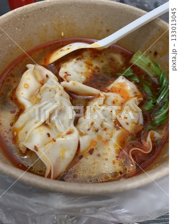Chili Oil Dumplings, delicate dumplings drenched in aromatic chili oil, topped with sesame seeds and scallions. A perfect balance of spice, savory filling, and rich flavors. 133013045