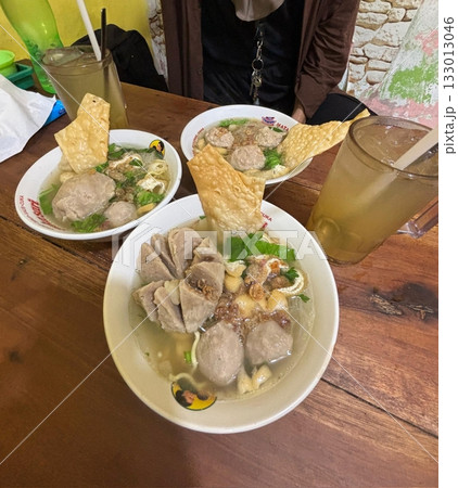 A bowl of Bakso Malang, featuring tender meatballs, fried dumplings, noodles, and savory broth. This iconic Indonesian dish offers a rich and hearty flavor perfect for any mealtime. A bowl of Bakso Malang, featuring tender meatballs, fried dumplings, noodles, and savory broth. This iconic Indonesian dish offers a rich and hearty flavor perfect for any mealtime. 133013046