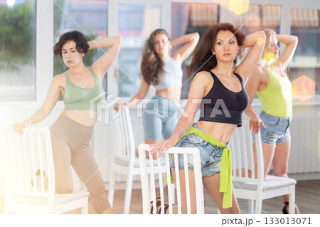 Brunette leading group exotic chair dance class in studio Brunette leading group exotic chair dance class in studio 133013071