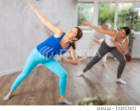 Happy women practicing aerobics in light fitness studio 133013072
