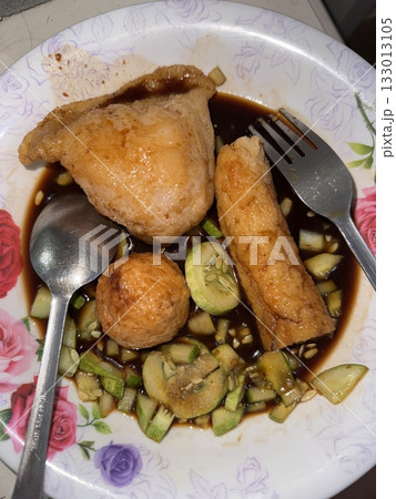 Pempek, a delicious Indonesian fishcake served with a tangy, sweet-sour vinegar sauce. Perfect for food photography and showcasing traditional Indonesian street food, rich in flavor and texture. 133013105