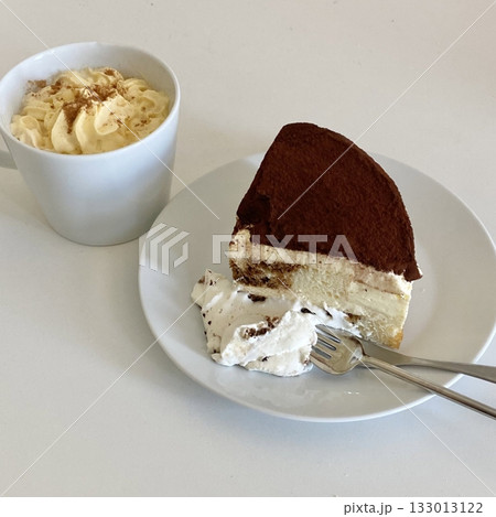 Soft and creamy tiramisu slice layered with rich mascarpone, espresso-soaked ladyfingers, and a dusting of cocoa powder, offering a perfect balance of sweetness and bold coffee flavor in every bite. 133013122