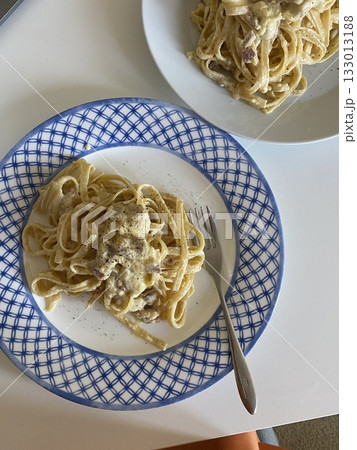 Creamy spaghetti carbonara made with rich egg yolk sauce, crispy bacon, parmesan cheese, and freshly ground black pepper for a classic, indulgent Italian pasta dish. 133013188