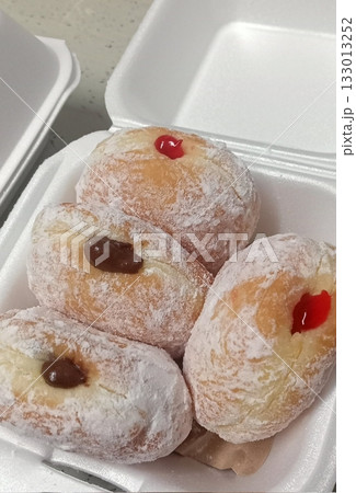 Bomboloni, soft Italian doughnuts filled with creamy custard or jam, dusted with powdered sugar. Fluffy and indulgent, they’re a perfect sweet treat, enjoyed fresh and warm with every bite. 133013252