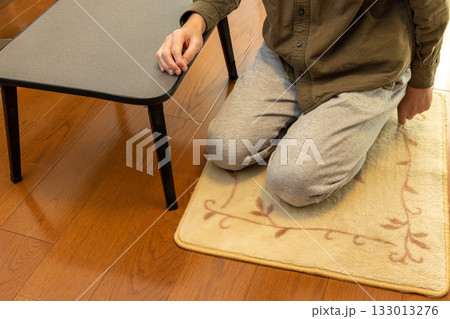 床に敷いたカーペットの上に正座で座る男性 133013276