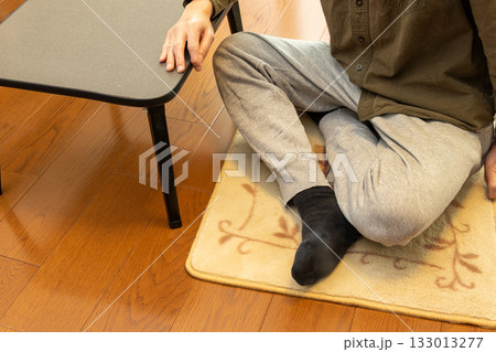 床に敷いたカーペットの上でくつろぐ男性 133013277