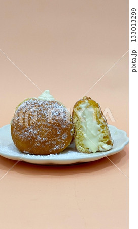 Bomboloni, soft Italian doughnuts filled with creamy custard or jam, dusted with powdered sugar. Fluffy and indulgent, they’re a perfect sweet treat, enjoyed fresh and warm with every bite. Bomboloni, soft Italian doughnuts filled with creamy custard or jam, dusted with powdered sugar. Fluffy and indulgent, they’re a perfect sweet treat, enjoyed fresh and warm with every bite. 133013299