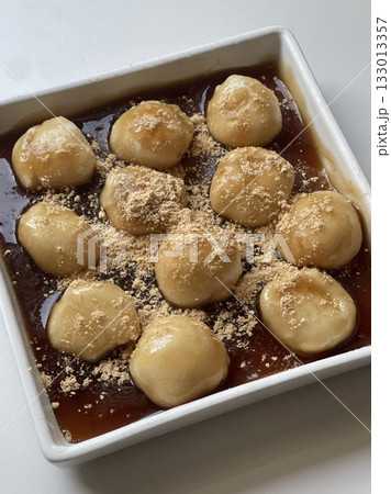Mitarashi dango, skewered rice dumplings glazed with a sweet soy sauce syrup, offering a delightful balance of sweetness and umami. A classic Japanese snack perfect for any occasion. 133013357