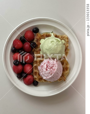 Crispy, golden waffles topped with creamy ice cream, creating a perfect balance of warm and cold, crunchy and smooth. A delightful dessert or breakfast treat, with toppings like fruits or syrup. Crispy, golden waffles topped with creamy ice cream, creating a perfect balance of warm and cold, crunchy and smooth. A delightful dessert or breakfast treat, with toppings like fruits or syrup. 133013358