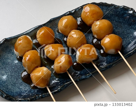 Mitarashi dango, skewered rice dumplings glazed with a sweet soy sauce syrup, offering a delightful balance of sweetness and umami. A classic Japanese snack perfect for any occasion. Mitarashi dango, skewered rice dumplings glazed with a sweet soy sauce syrup, offering a delightful balance of sweetness and umami. A classic Japanese snack perfect for any occasion. 133013402