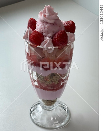 Healthy breakfast of strawberry parfait made with fresh fruit, and yogurt over a rustic white table. Selective focus with blurred background and foreground. Healthy breakfast of strawberry parfait made with fresh fruit, and yogurt over a rustic white table. Selective focus with blurred background and foreground. 133013443