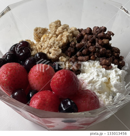 A bowl of yogurt with oats and fresh fruits offers a healthy and delicious combination, perfect for breakfast or a snack. The creamy yogurt blends with crunchy oats and the sweetness of fruits 133013456