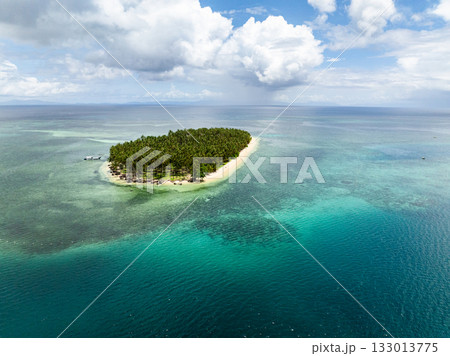 Remote island covered with palm trees surrounded by turquoise clear water and coral reef. Siargao, Philippines. Casa Desideria. 133013775
