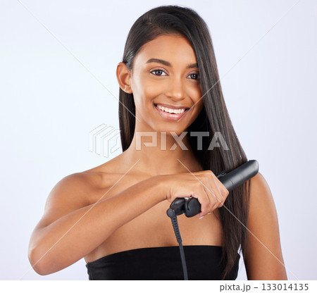 Haircare, beauty and woman with a straightener in studio for a straight, long and healthy hairstyle. Happy, smile and portrait of a female model with flat iron after hair treatment by gray background Haircare, beauty and woman with a straightener in studio for a straight, long and healthy hairstyle. Happy, smile and portrait of a female model with flat iron after hair treatment by gray background 133014135