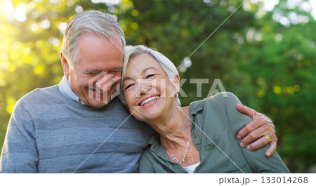 Laughing, love and senior couple in a park together hugging with care, happiness and romance. Smile, nature and elderly man and woman in retirement embracing while sitting in an outdoor green garden. 133014268