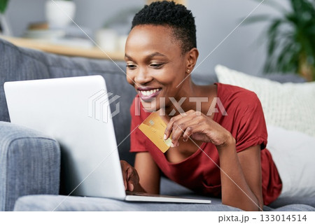 Laptop, credit card and black woman relax on a sofa for online shopping, e commerce and membership. Banking, credit score and female African person happy with payment, booking or customer experience Laptop, credit card and black woman relax on a sofa for online shopping, e commerce and membership. Banking, credit score and female African person happy with payment, booking or customer experience 133014514