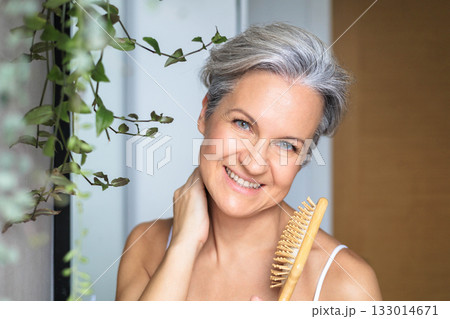 Portrait of a beautiful, smiling middle-aged European woman with gray hair in the bathroom Portrait of a beautiful, smiling middle-aged European woman with gray hair in the bathroom 133014671