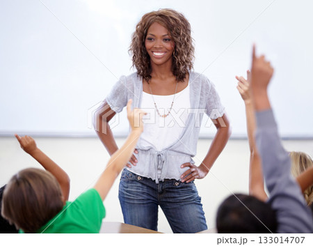 Classroom hands, raise and children with woman questions, education and language learning or quiz of school teacher. Happy, proud african person in teaching with kids support, ideas and group answer 133014707