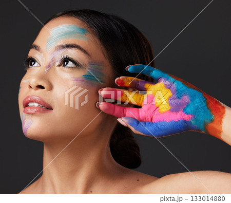 Woman, hand and beauty with rainbow paint art and face thinking in studio. Creative skin and makeup on female aesthetic model on gray background for lgbtq color inspiration and hope or peace on hands 133014880