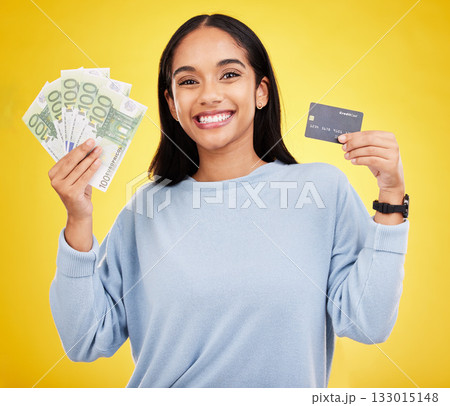 Woman, portrait smile and credit card with money for ecommerce, shopping or banking against a yellow studio background. Happy female shopper smiling and holding cash and debit from bank withdrawal 133015148