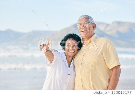 Old couple at beach, hug and travel with smile, retirement and love outdoor, vacation with view and relax in nature. Peace, zen and man with woman pointing, happiness and wellness in Bali on holiday 133015177
