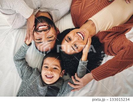 Family, laughing and top view portrait on bed in bedroom, bonding and care in home. Love, smile and happy mother, comic father and funny boy child playing, having fun and enjoying joke time together. Family, laughing and top view portrait on bed in bedroom, bonding and care in home. Love, smile and happy mother, comic father and funny boy child playing, having fun and enjoying joke time together. 133015234