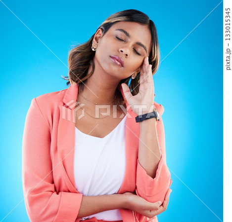 Burnout, stress and woman with headache, tension and girl against a blue studio background. Female, tired girl and first aid for migraine, mental health and overworked with deadline, schedule or pain 133015345