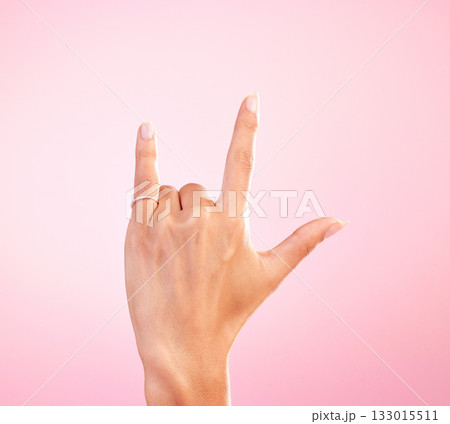 Sign language, funky and hand with a gesture for rock isolated on a pink background in a studio. Celebrate, deaf communication and person gesturing for metal music, emoji and expression on a backdrop 133015511