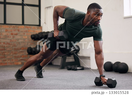 Black man, dumbbell row and training in gym, workout and strong fitness in health club. Serious sports athlete, bodybuilder and weight exercise on ground for energy, power and core strength challenge 133015528