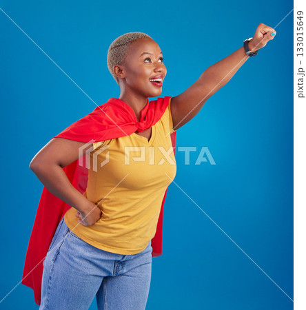 Black woman, superhero cape and flying in studio, blue background and pop culture fashion. Happy female model, cosplay character and superwoman costume of fist, courage or action of strong girl power Black woman, superhero cape and flying in studio, blue background and pop culture fashion. Happy female model, cosplay character and superwoman costume of fist, courage or action of strong girl power 133015649