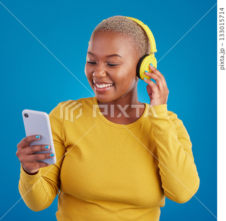 Search, phone and music with black woman in studio for streaming, multimedia and browsing. Gen z, smile and audio with female and headphones on blue background for listening, online radio and songs Search, phone and music with black woman in studio for streaming, multimedia and browsing. Gen z, smile and audio with female and headphones on blue background for listening, online radio and songs 133015714
