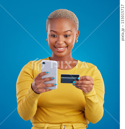 Online shopping, credit card and black woman with phone in studio for ecommerce on blue background. Debit, fintech app and girl with subscription, membership or budget, payment and banking Online shopping, credit card and black woman with phone in studio for ecommerce on blue background. Debit, fintech app and girl with subscription, membership or budget, payment and banking 133015717