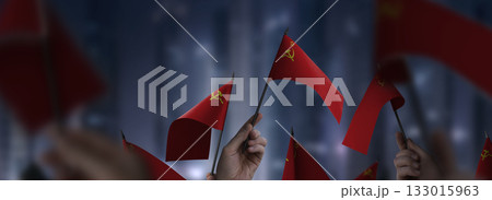 USSR flags in their hands on a blurred urban background USSR flags in their hands on a blurred urban background 133015963