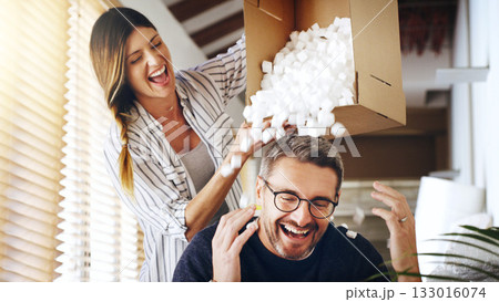 Moving house, real estate and box with a crazy married couple having fun while playing in their new home together. Property, comic or foam with a playful husband and wife joking in the living room 133016074