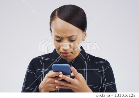 Confused, phone and woman typing in studio isolated on a white background. Problem, cellphone and female person frustrated on app, fake news or browsing online, social media and glitch, spam or scam. Confused, phone and woman typing in studio isolated on a white background. Problem, cellphone and female person frustrated on app, fake news or browsing online, social media and glitch, spam or scam. 133016128