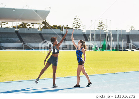 Woman, team and high five on stadium track for running, exercise or training together in athletics outdoors. Women touching hands in celebration for exercising, run or winning in teamwork and fitness Woman, team and high five on stadium track for running, exercise or training together in athletics outdoors. Women touching hands in celebration for exercising, run or winning in teamwork and fitness 133016272