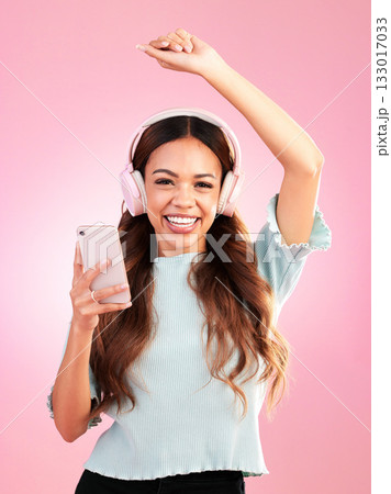 Music headphones, phone and portrait of woman in studio isolated on a pink background. Smile, radio dance and happy female with mobile streaming, enjoying and listening to audio, sound or podcast. Music headphones, phone and portrait of woman in studio isolated on a pink background. Smile, radio dance and happy female with mobile streaming, enjoying and listening to audio, sound or podcast. 133017033