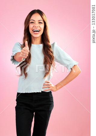 Happy, thumbs up and portrait of a woman in a studio with success, agreement and achievement. Happiness, smile and female model from Puerto Rico posing with a yes gesture isolated by pink background. 133017081