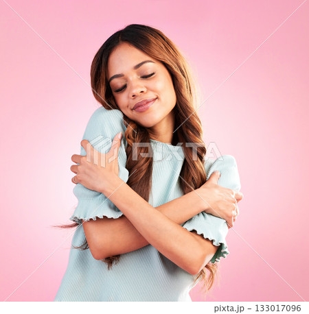 Happy woman, self love and inner peace hug in studio for body positivity, acceptance and joy on pink background. Smile, care and girl embracing authentic, natural and positive mindset while isolated 133017096