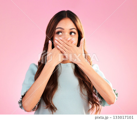 Quiet, surprise and a beautiful woman with a secret isolated on a pink background in a studio. Wow, embarrassed and a girl covering her mouth with a hand for gossip, expression and amazement 133017101