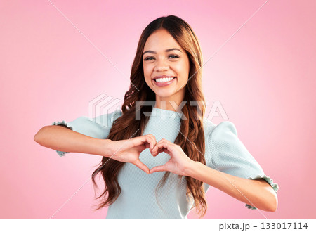 Love, heart hands and portrait of woman in studio for romance, positive and kindness. Peace, support and emoji with female and shape isolated on pink background for emotion, hope and happy gesture 133017114