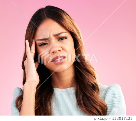 Stress, burnout and woman with headache in studio, tired or exhausted on pink background. Mental health, depression and anxiety, overworked hispanic model with hand on head in pain and temple massage 133017123