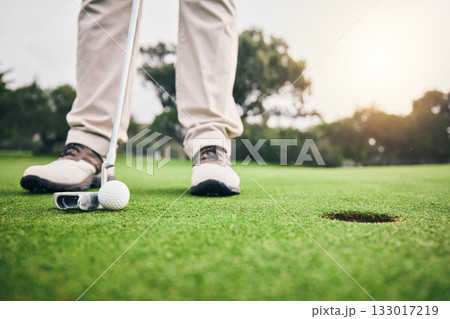 Golf, hole and player hit ball and professional athlete training and putting on a filed as exercise or workout. Sportsman, equipment and gentleman golfer or person relax and playing a sport 133017219