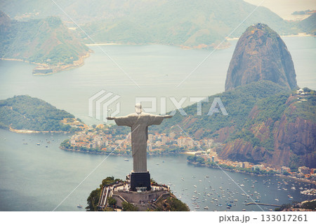 Statue, monument and Christ the Redeemer on mountain for tourism, sightseeing and travel destination. Traveling, Rio de Janeiro and aerial view of symbol, sculpture and city landmark by Brazil ocean 133017261