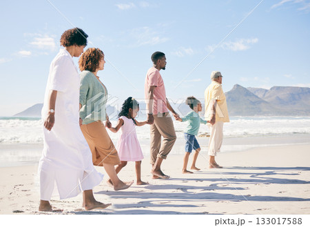 Family is walking on beach, travel and holding hands with generations, unity and freedom with love, together outdoor. Grandparents, parents and children, people on holiday with tropical destination Family is walking on beach, travel and holding hands with generations, unity and freedom with love, together outdoor. Grandparents, parents and children, people on holiday with tropical destination 133017588